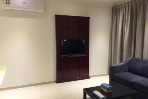 a living room with a couch and a flat screen tv at تأجير شهري وسنوي in Al Khobar