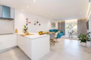 a kitchen and living room with white cabinets at Apartamento Centro de Albufeira Sunny in Albufeira