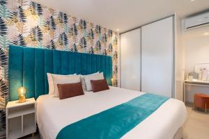 a bedroom with a large bed with a blue headboard at Apartamento Centro de Albufeira Sunny in Albufeira +13 photos