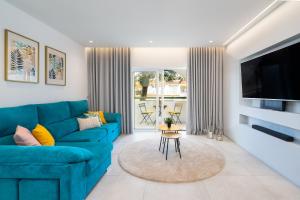 ein Wohnzimmer mit einem blauen Sofa und einem TV in der Unterkunft Sunny in Albufeira