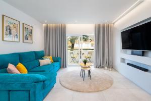 a living room with a blue couch and a tv at Apartamento Centro de Albufeira Sunny in Albufeira