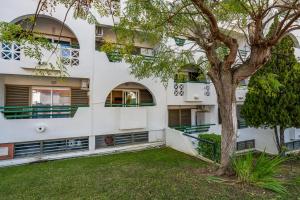 an apartment building with a tree in front of it at Apartamento Centro de Albufeira Sunny in Albufeira