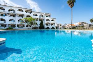 a large swimming pool in front of a building at Apartamento Centro de Albufeira Sunny in Albufeira