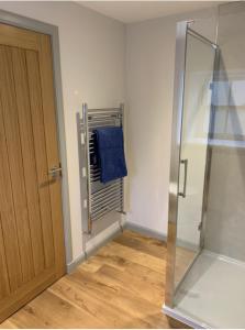 a bathroom with a shower and a blue towel at Lochhournhead B&B & Tea Room in Invergarry