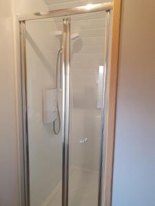 a shower with a glass door in a bathroom at Grimsay Glamping, North Uist - Pod Glas in Rossinish