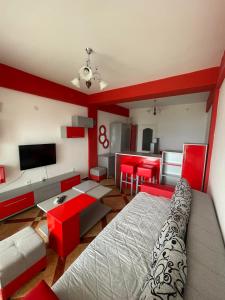 um quarto com uma cama e uma sala de estar com paredes vermelhas em Apartments Luna Azura em Ohrid