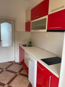 uma cozinha com armários vermelhos e um lavatório em Apartments Luna Azura em Ohrid