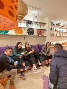 Un gruppo di persone sedute su un divano a giocare a un videogioco di Miostello Lifestyle Hostel Marrakech a Marrakech