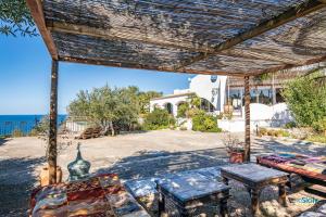 een patio met een tafel en banken en de oceaan bij Villa Giacona Venuti in Terrasini