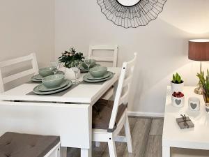 mesa de comedor blanca y sillas con mesa blanca y sillón en Devonshire Nook, en Chinley