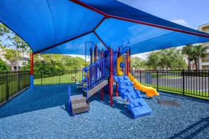 a playground with a blue canopy and a slide at Brand New Modern Vista Cay Reserve Condo - 5003 in Orlando