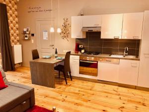 a kitchen with white cabinets and a table with chairs at Chez Maïlis in Rhisnes