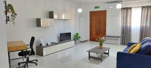 a living room with a blue couch and a television at Modern, spacious and bright apt in centre of Malta in Mosta