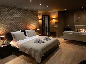 a bedroom with a large bed and a couch at Suite & Wellness in Breskens