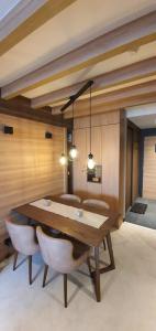 a dining room with a wooden table and chairs at MR. O Apartments Woodside Kopaonik in Kopaonik