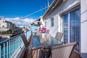 a table on a balcony with a vase of flowers at Loft Apt with Acropolis View in Athens