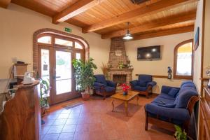 ein Wohnzimmer mit blauen Stühlen und einem Kamin in der Unterkunft Agriturismo Caperroni in Pescopagano