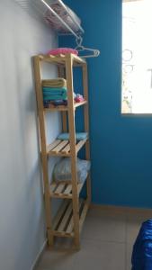 estantería de madera en una habitación con toallas en Apartamento compacto, en Natal