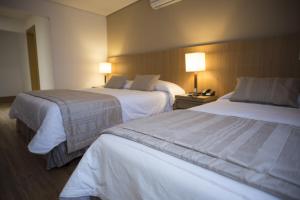 a hotel room with two beds and two lamps at Casablanca Center Hotel in Petrópolis