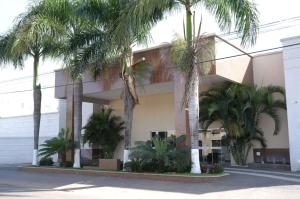 un bâtiment avec des palmiers en face de celui-ci dans l'établissement Otimo apto c piscina e Wi Fi em Caldas Novas GO, à Caldas Novas