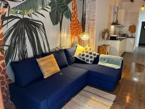 a blue couch in a living room with a giraffe mural at El negrito, apartamento centro in Valencia