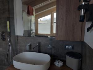 a bathroom with a large white tub and a mirror at Lucas Haus in Livigno