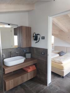 a bathroom with a sink and a bed and a tub at Lucas Haus in Livigno