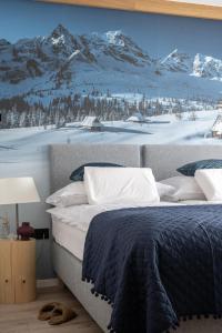 a bedroom with a bed with a snow covered mountain mural at Apartament LUNA APARTZAKOP in Zakopane