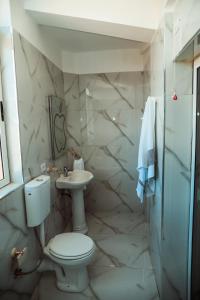 y baño con aseo y lavamanos. en Rezidenca Medi Nako, en Korçë