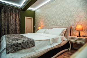 Un dormitorio con una cama grande y una mesa con una lámpara. en Rezidenca Medi Nako, en Korçë