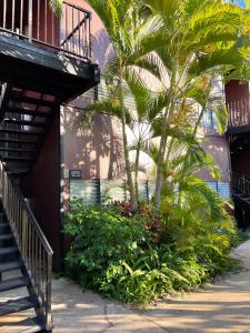a building with palm trees next to a sidewalk at Ka Hale Kealoha in Kaunakakai