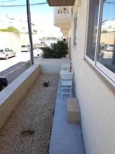 a patio with two chairs and a bench next to a window at Modern, spacious and bright apt in centre of Malta in Mosta