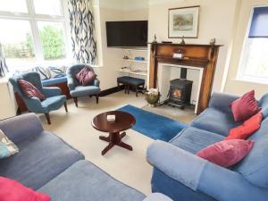 a living room with blue couches and a fireplace at Moor House in Tirril