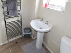 Baño blanco con lavabo y aseo en Moor House en Tirril