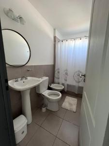 y baño con lavabo, aseo y espejo. en Multi home en Concepción del Uruguay