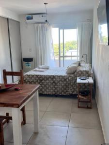 1 dormitorio con 1 cama y 1 mesa en una habitación en Multi home en Concepción del Uruguay