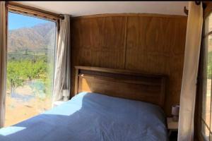 a bedroom with a bed and a large window at Altos de Curacavi in Curacaví