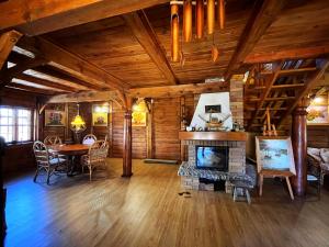 a living room with a fireplace and a dining table at Dom Karwia in Karwia