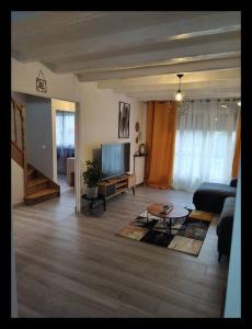 uma sala de estar com um sofá e uma televisão em COSY HOME - Wifi - Paris/Orly - Accès 24/24 em Sainte-Geneviève-des-Bois