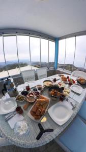 une table avec des assiettes de nourriture au-dessus d'un bateau dans l'établissement Kartal Gözü Konaklama tesisi, à Rize