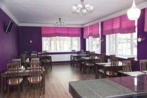 comedor con mesas, sillas y paredes púrpuras en Meridian Domodedovo, en Domodedovo