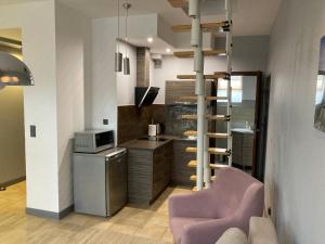 a kitchen with a purple chair and a kitchen with a stove at Apartament Giżycko in Giżycko