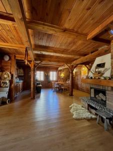 Dom Karwia في كارفيا: غرفة معيشة كبيرة مع موقد وسقوف خشبية