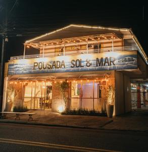 a building with a sign that reads poulada soos and mar at Pousada Sol & Mar in Guaratuba