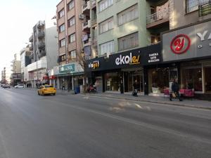 a city street with buildings and a yellow taxi at ŞİRİNYER APART OTEL in Izmir