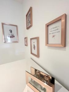 a white wall with framed pictures and a shelf at Appartement cosy & reposant in Beauvais