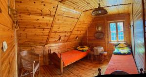 a log cabin bedroom with a bed and two chairs at Dom Karwia in Karwia