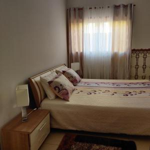 Dormitorio pequeño con cama y ventana en Prothea Home, en Vila Chã