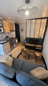 a living room with a blue couch and a kitchen at Studio cosy Saint-Étienne centre ville in Saint-Étienne