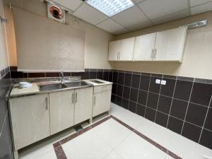 a kitchen with white cabinets and a sink at المهاجرين فرع الحزام in Medina